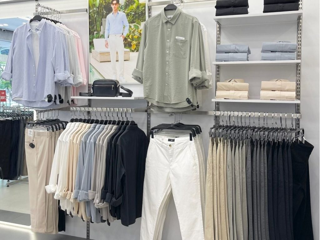 Kệ trưng bày sơ mi và quần nam tại cửa hàng — tiêu chí chọn xưởng sỉ thời trang nam uy tín